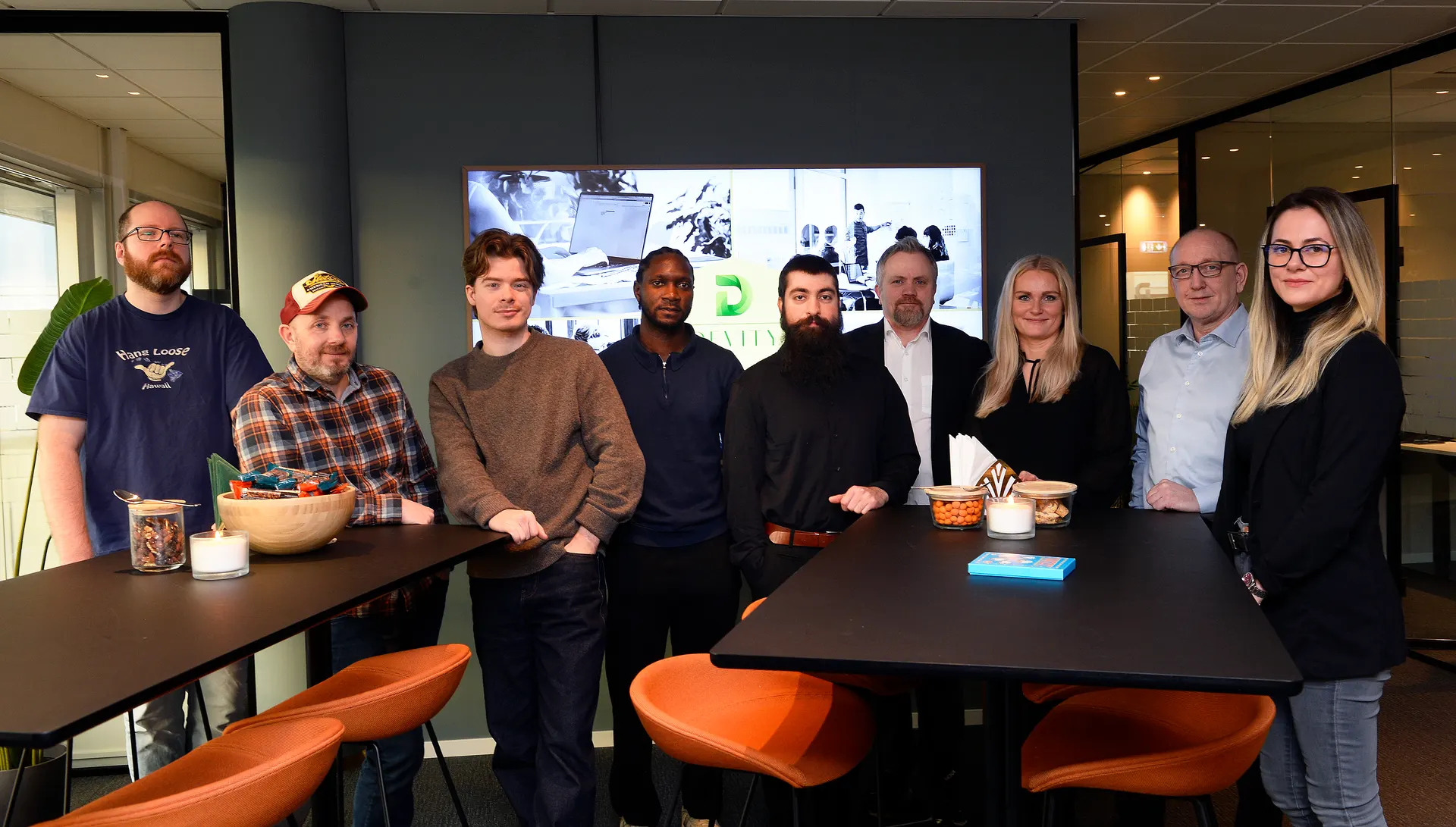 Devity-teamet samlet i rom med oransje stoler